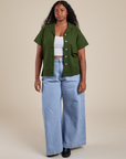 Meghna is wearing Pantry Button-Up in Evergreen and light wash Indigo Wide Leg Trousers