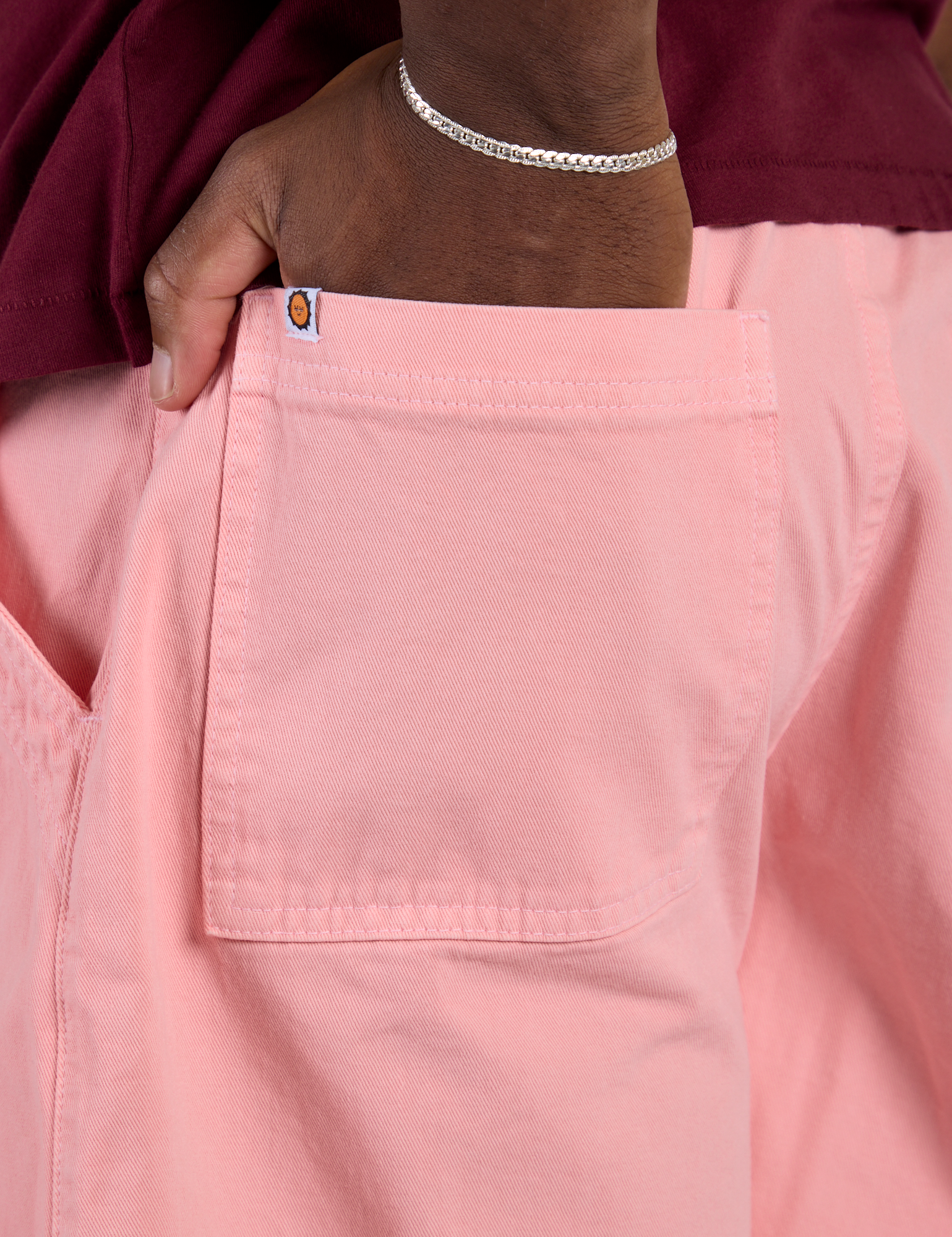 Close up of Isaac's hand in the back pocket of Longline Work Shorts in Baby Pink