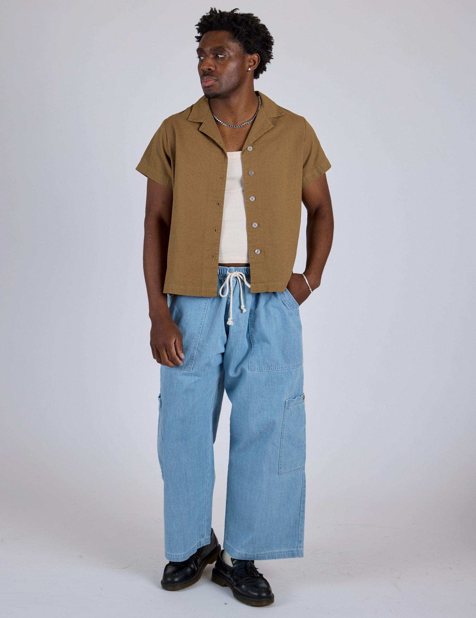 Isaac is wearing Pantry Button-Up in Desert Brown and light wash Denim Drop Pocket Pants