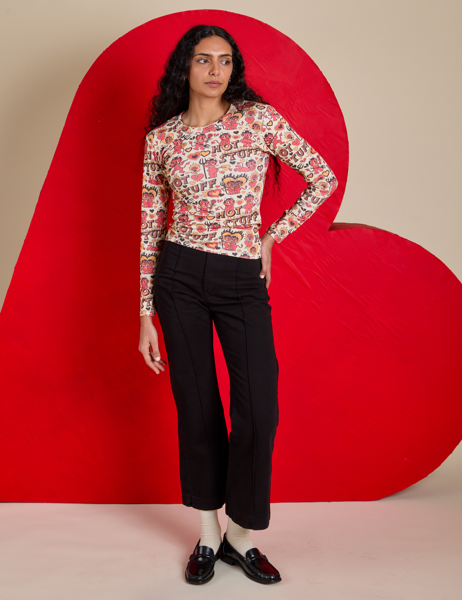 Shahana is wearing Long Sleeve Baby Tee in Hot Stuff Print tucked into black Western Pants