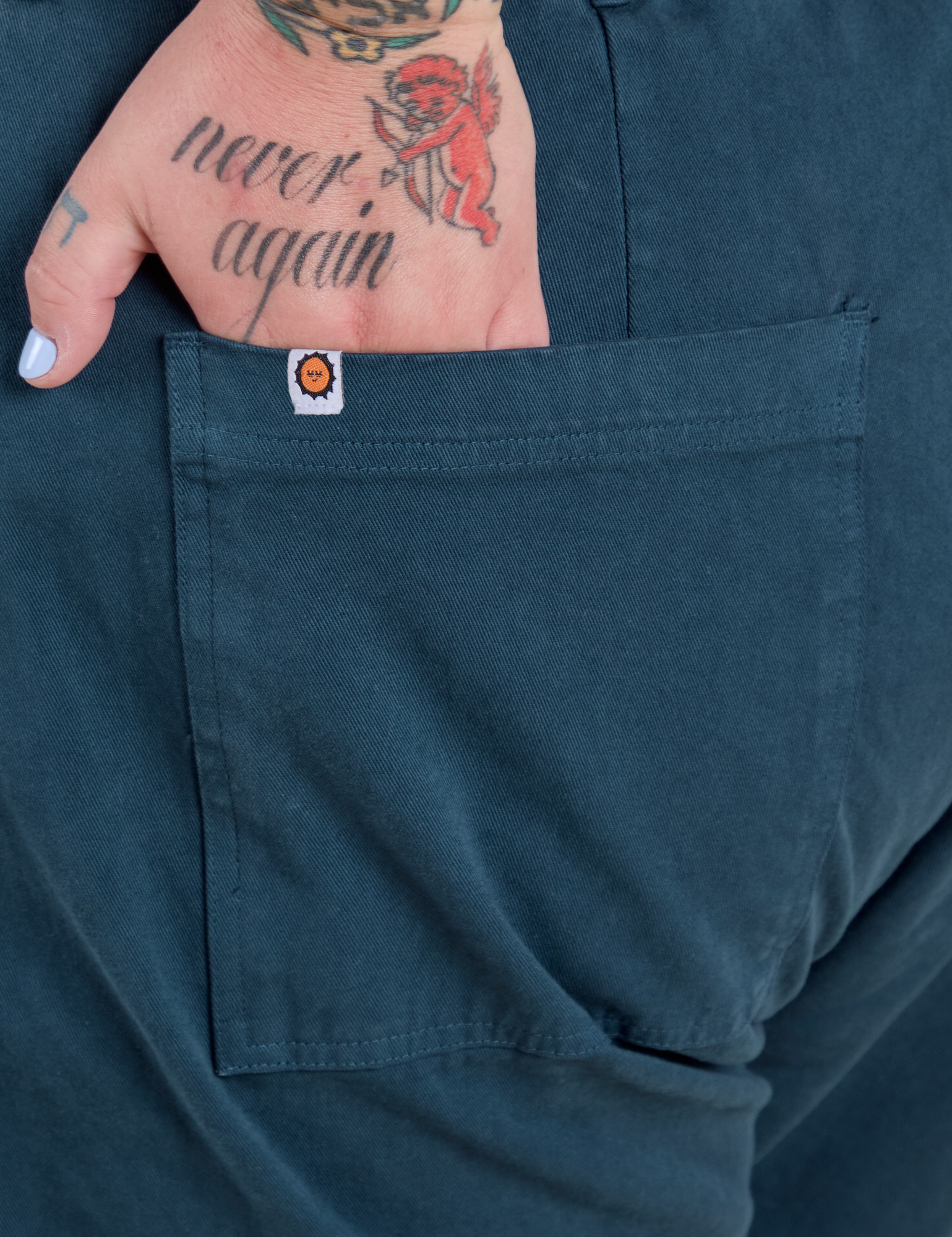 Close up of Sam's hand in the back pocket of Work Pants in Lagoon