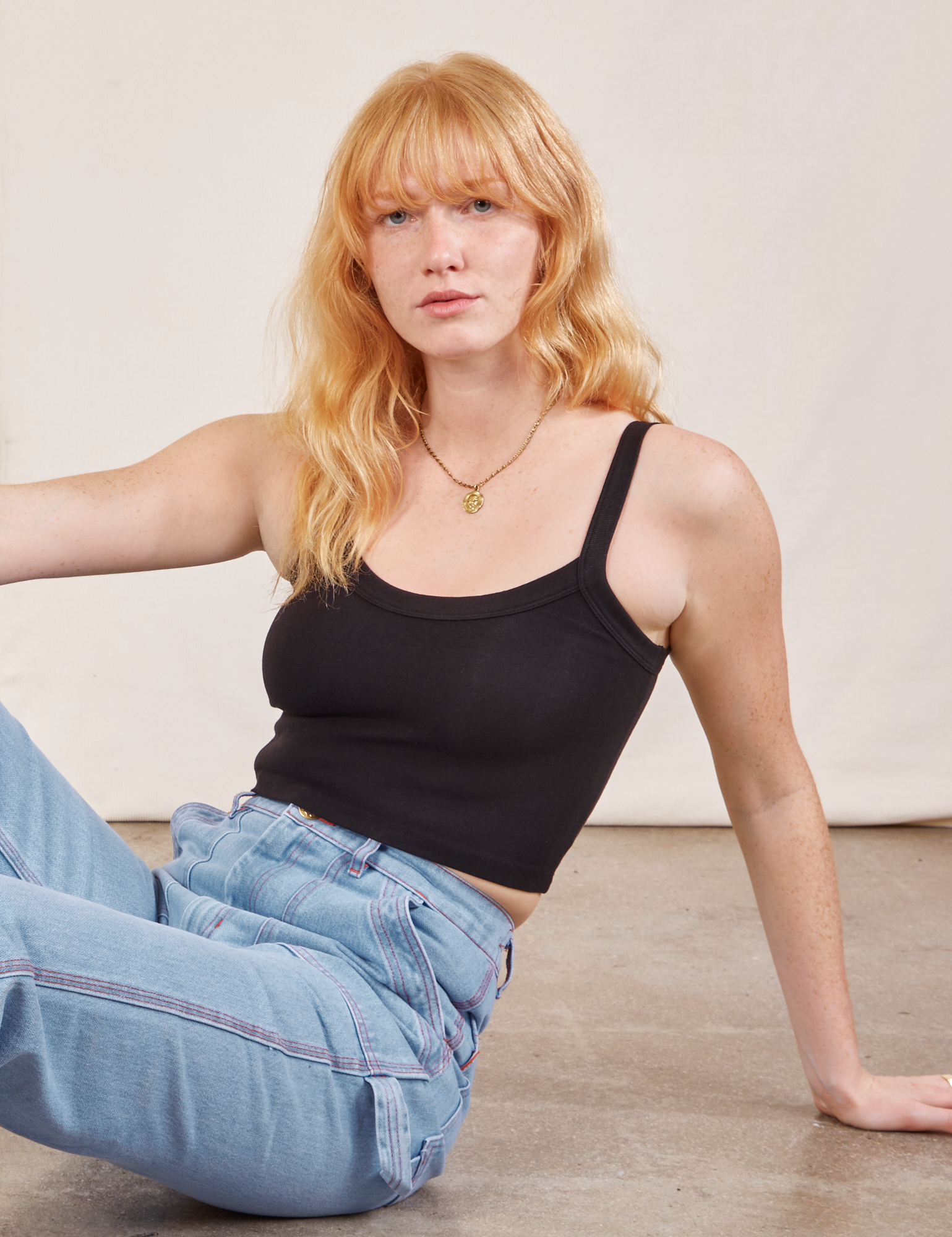 Margaret is wearing Cropped Cami in Basic Black and light wash Carpenter Jeans
