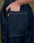 Close up of Alex's hand in the back pocket of Denim Drop Pocket Pants in Dark Wash