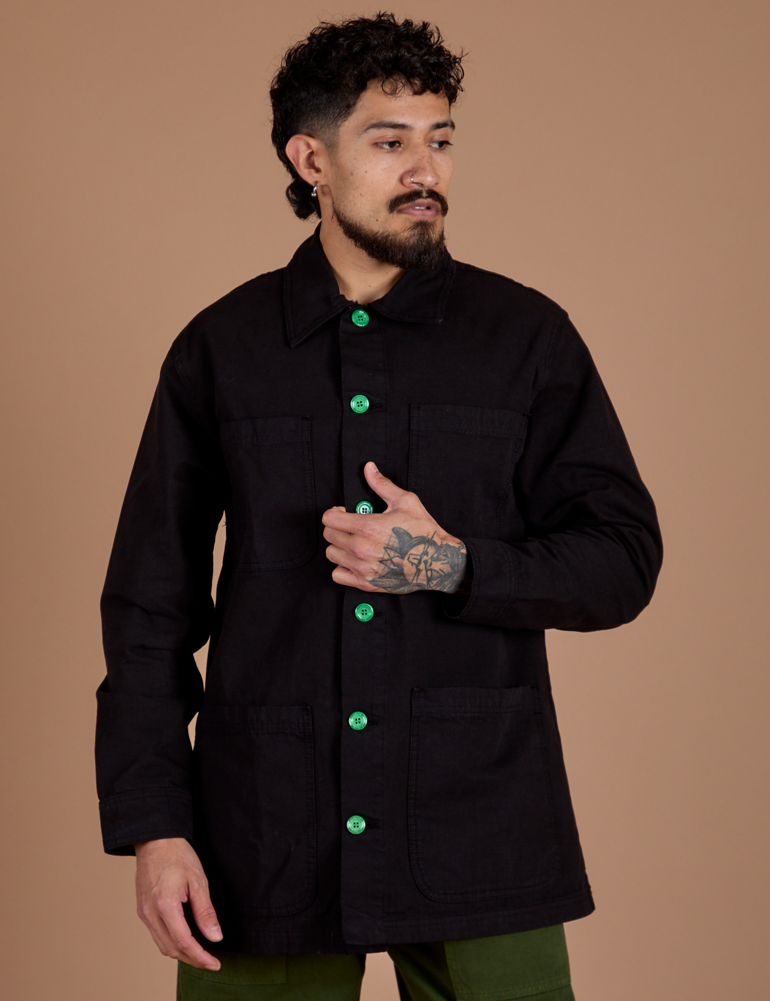 Jesse is wearing a buttoned up Ripstop Field Coat in Basic Black