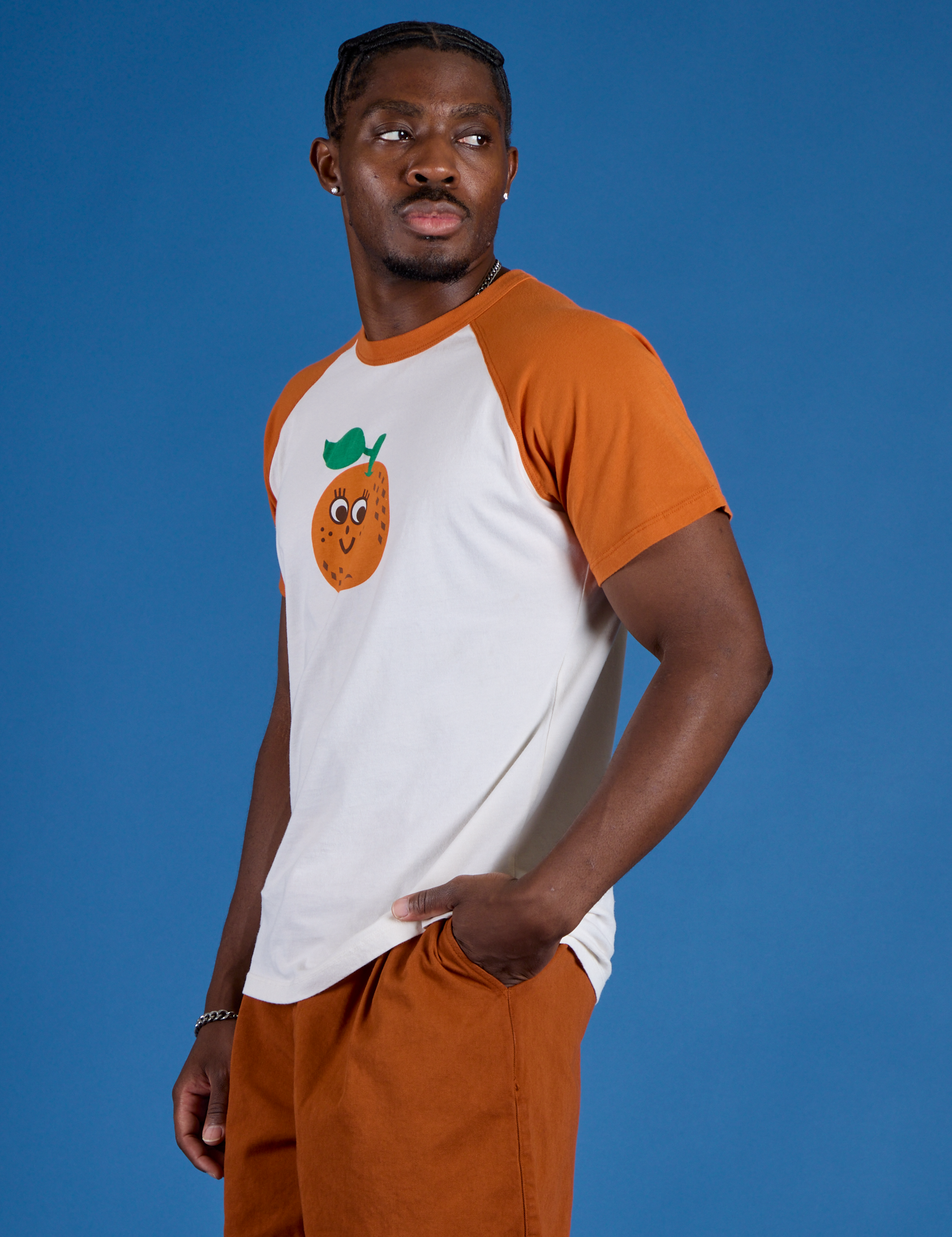 Angled front view of Produce Raglan Tee in Orange on Isaac