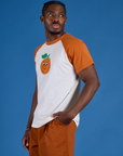 Angled front view of Produce Raglan Tee in Orange on Isaac