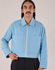 Anthony is wearing a zipped up Mechanic Jacket in Baby Blue