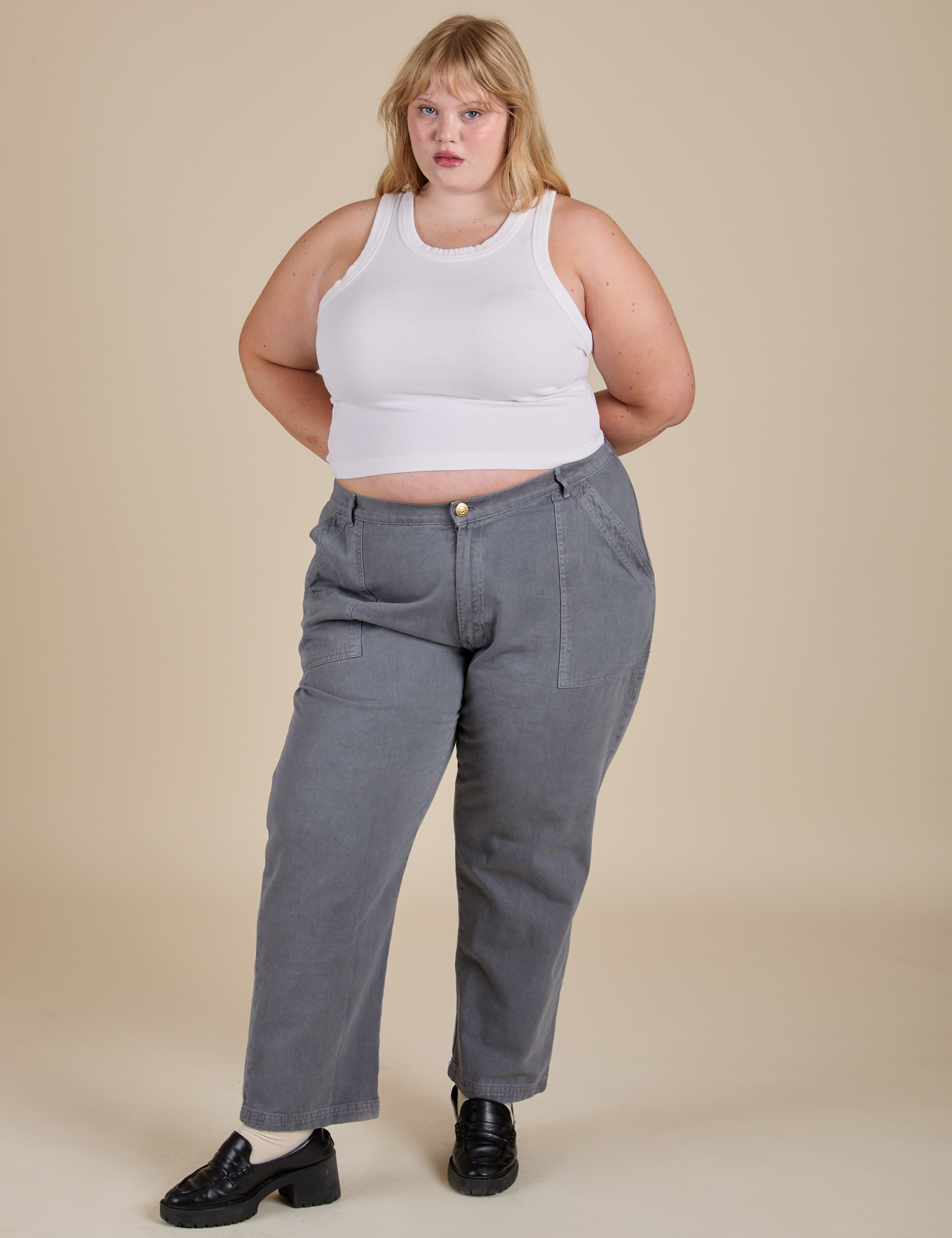 Juliet is wearing Racerback Tank in Vintage Tee White and washed grey Work Pants