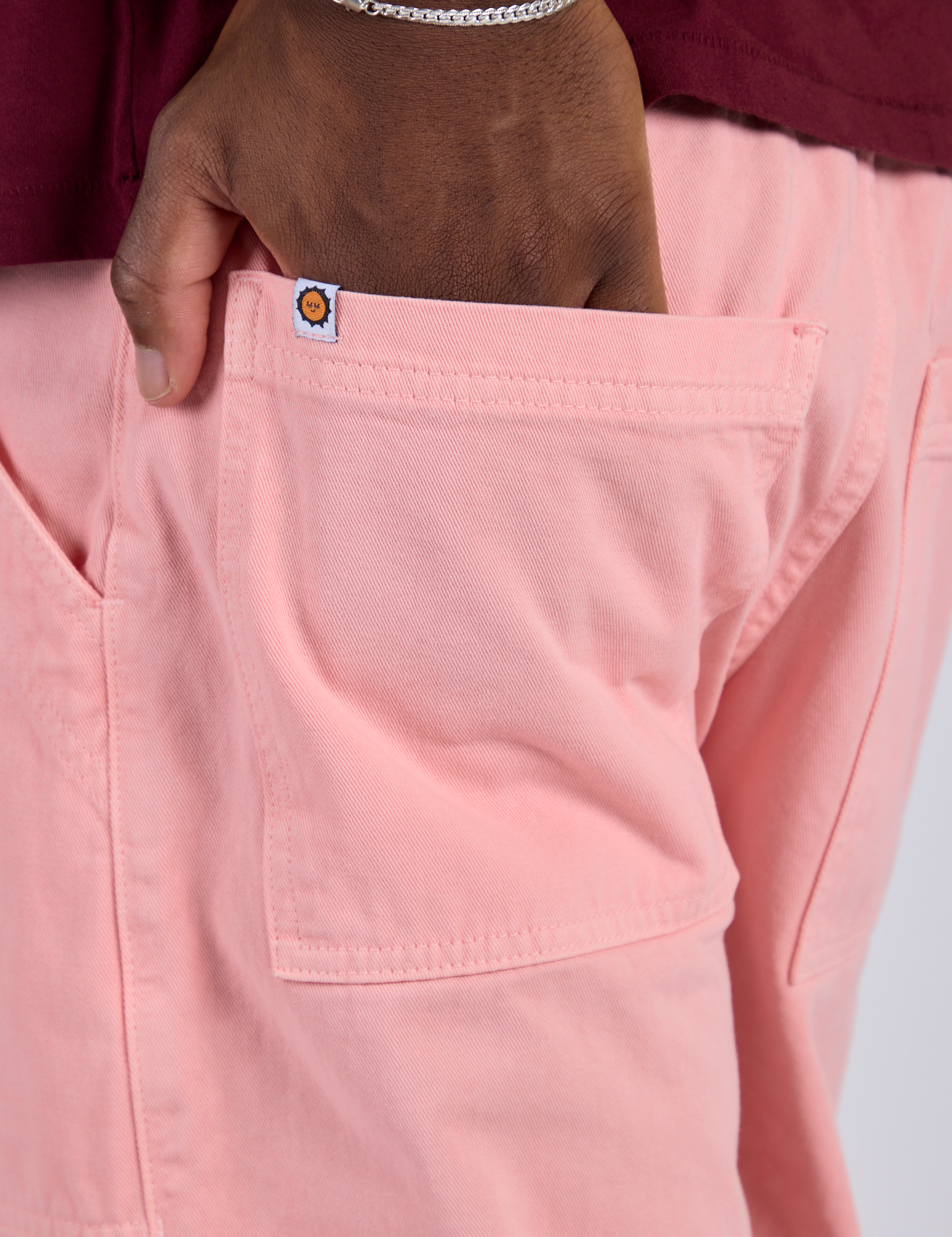 Close up of Isaac's hand in the back pocket of Work Pants in Baby Pink