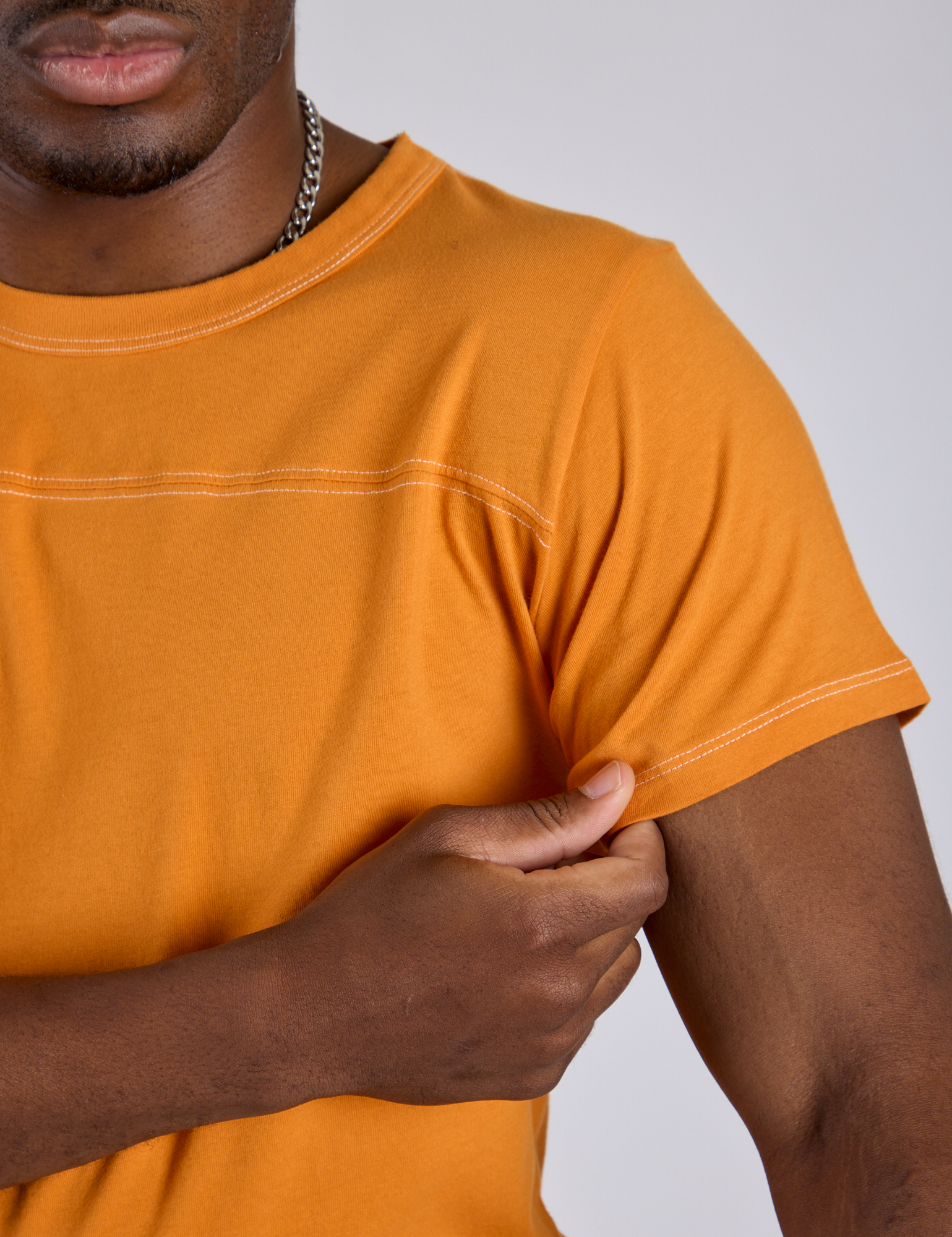 Close up of Jr. Varsity Tee in Creamsicle Orange on Isaac