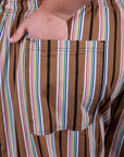 Close up of Juliet's hand in the back pocket of Striped Drop Pocket Pants in Retro Rainbow