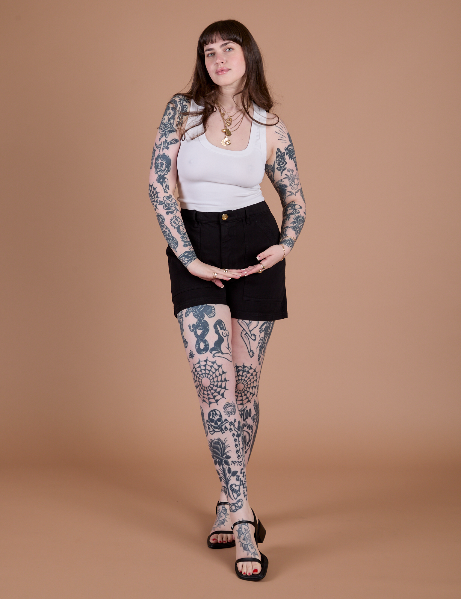Sydney is 5’9” and wearing M Classic Work Shorts in Basic Black paired with a Cropped Tank in Vintage Tee White