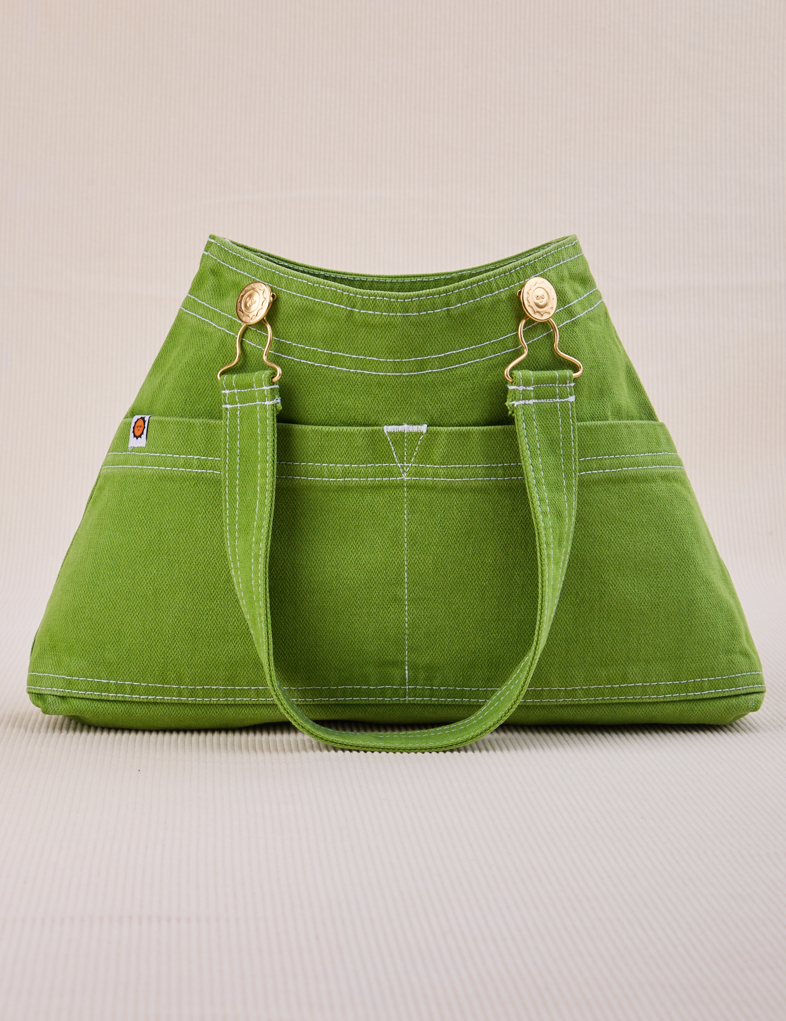 Overall Handbag in Bright Olive with handle strap down 