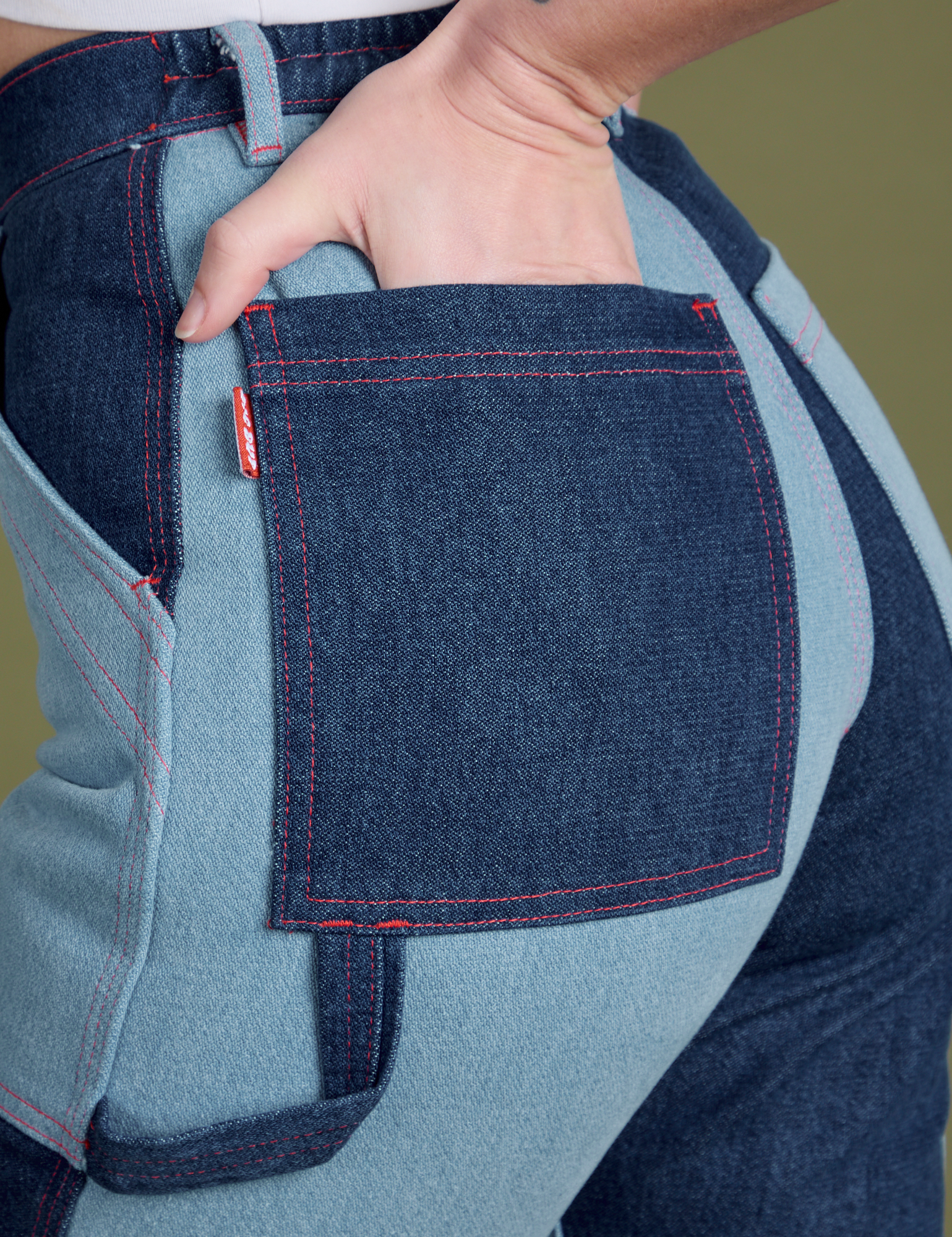 Close up of Alex's hand in the back pocket of Mismatched Denim Carpenter Jeans
