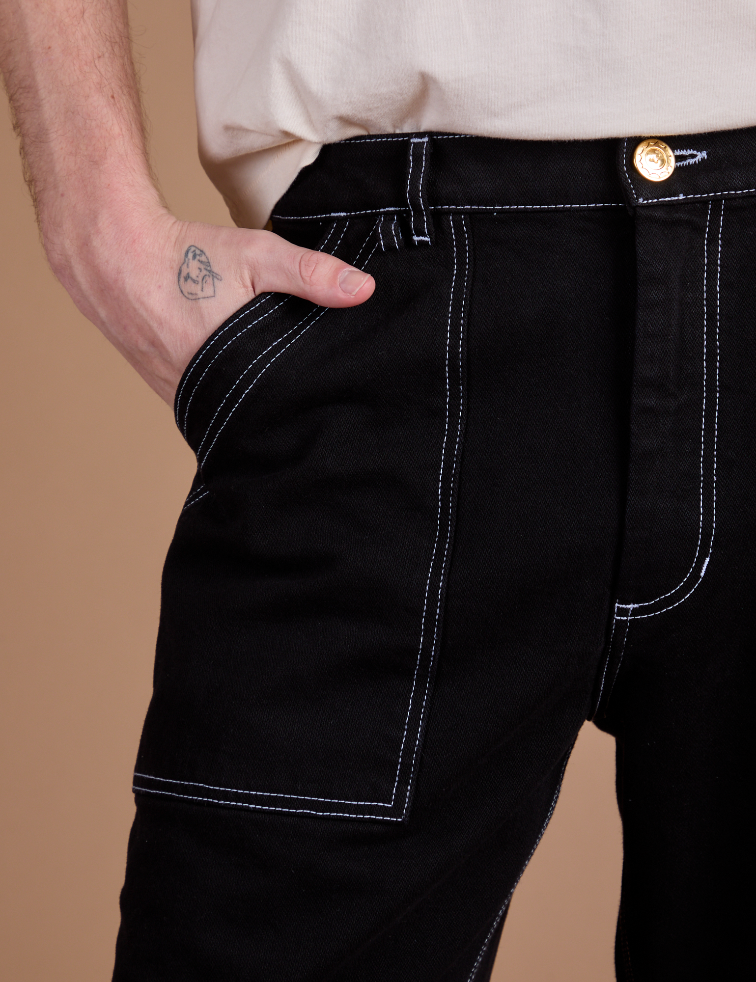 Close up of Quinn's hand in the front pocket of Carpenter Jeans in Black
