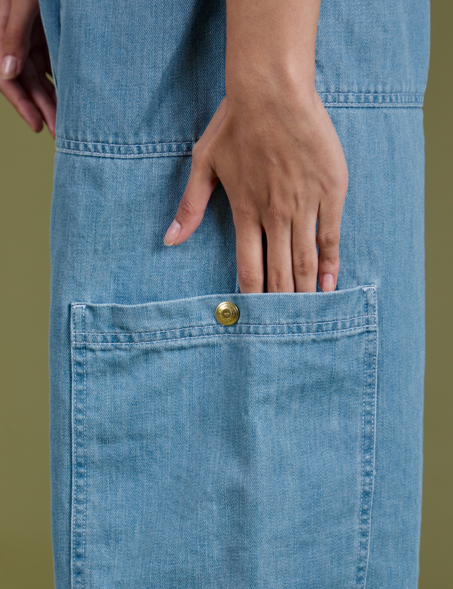 Close up of Anjaline's hand in the pant leg side pocket of Denim Drop Pocket Pants in Light Wash