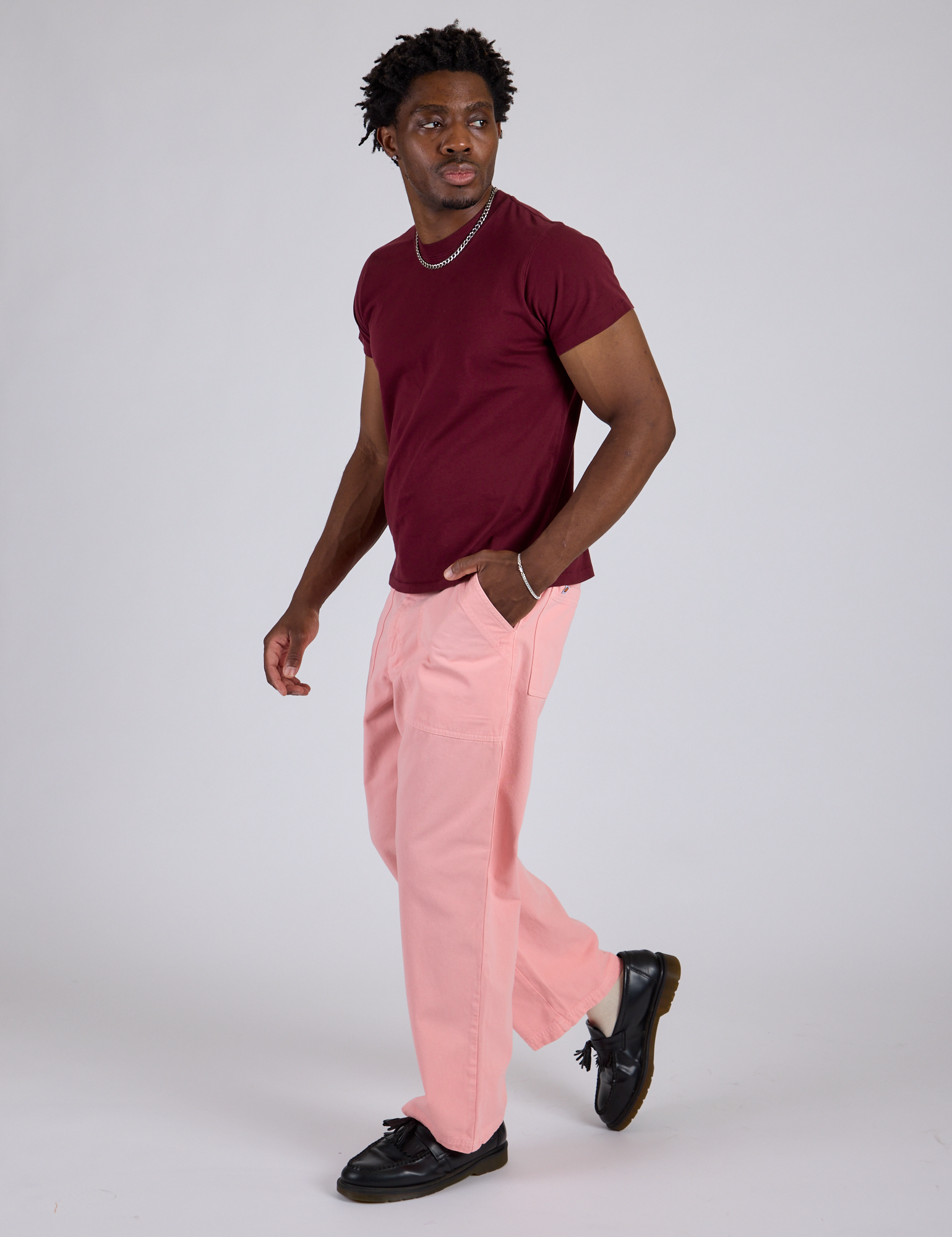 Angled front view of Work Pants in Baby Pink and red wine Organic Vintage Tee on Isaac