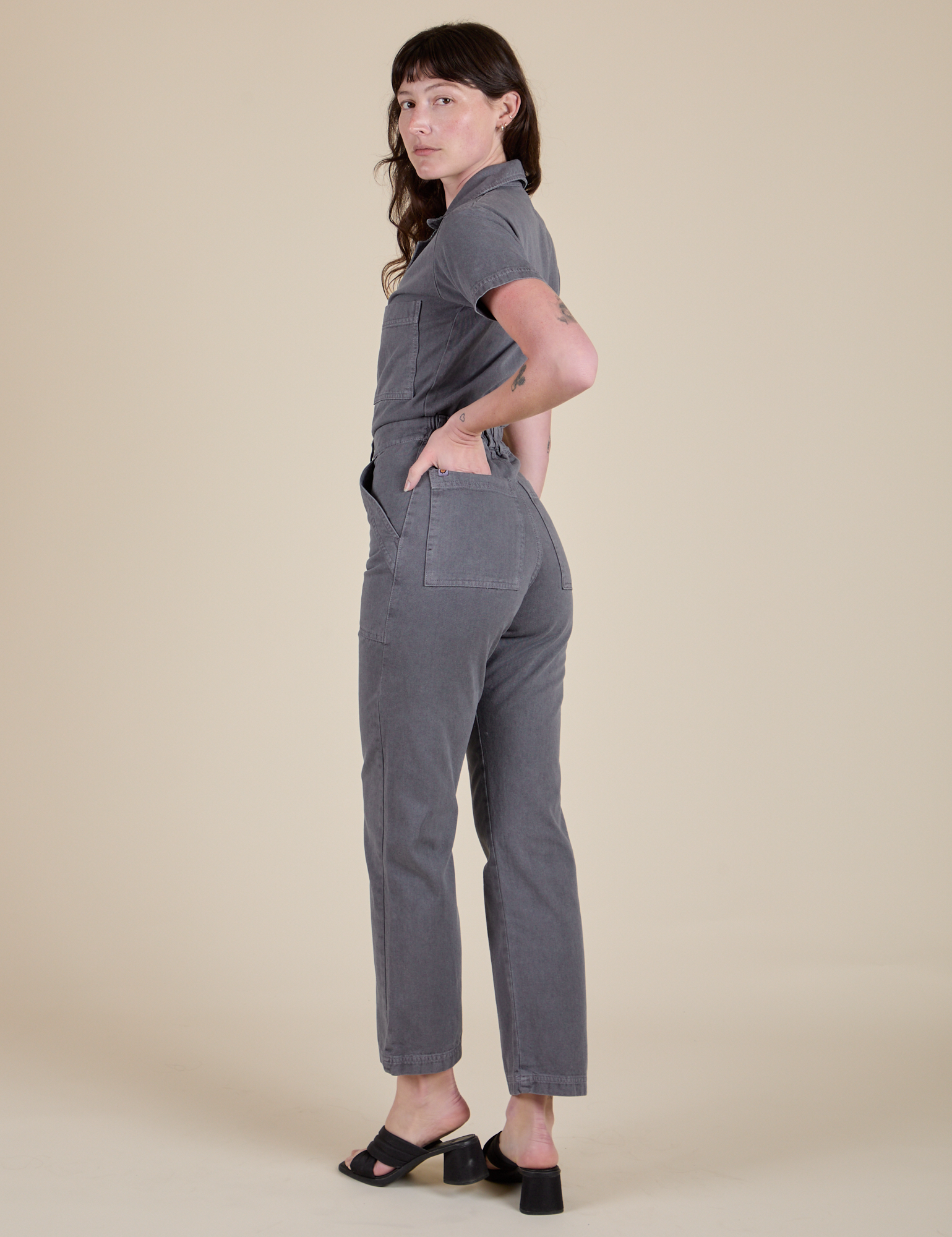 Angled back view of Short Sleeve Jumpsuit in Washed Grey on Alex