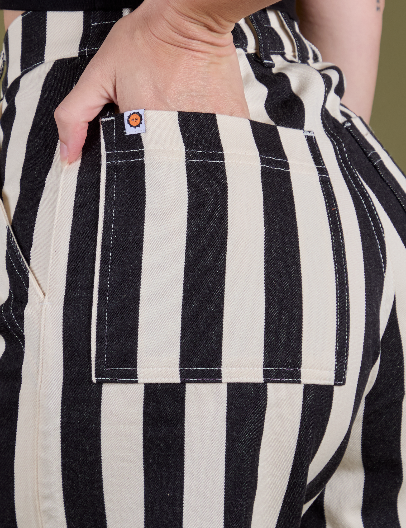 Close up of Alex's hand in the back pocket of Longline Work Shorts in Natural
