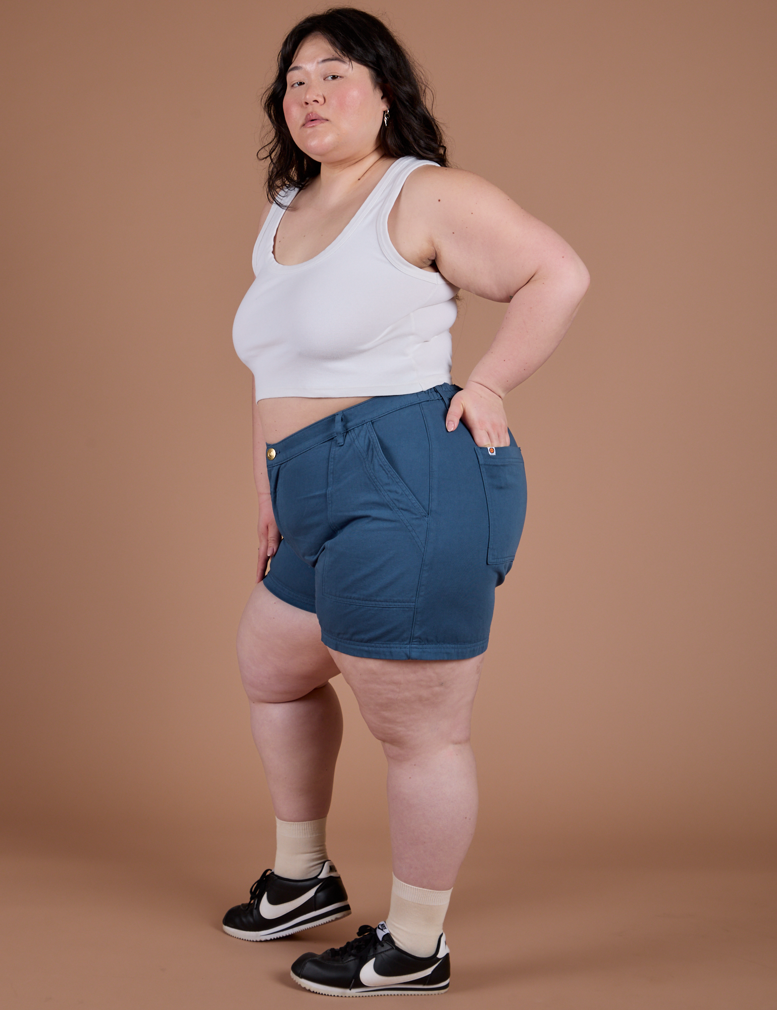 Ashley is 5’7” and wearing 1XL Classic Work Shorts in French Blue paired with a Cropped Tank in Vintage Tee White