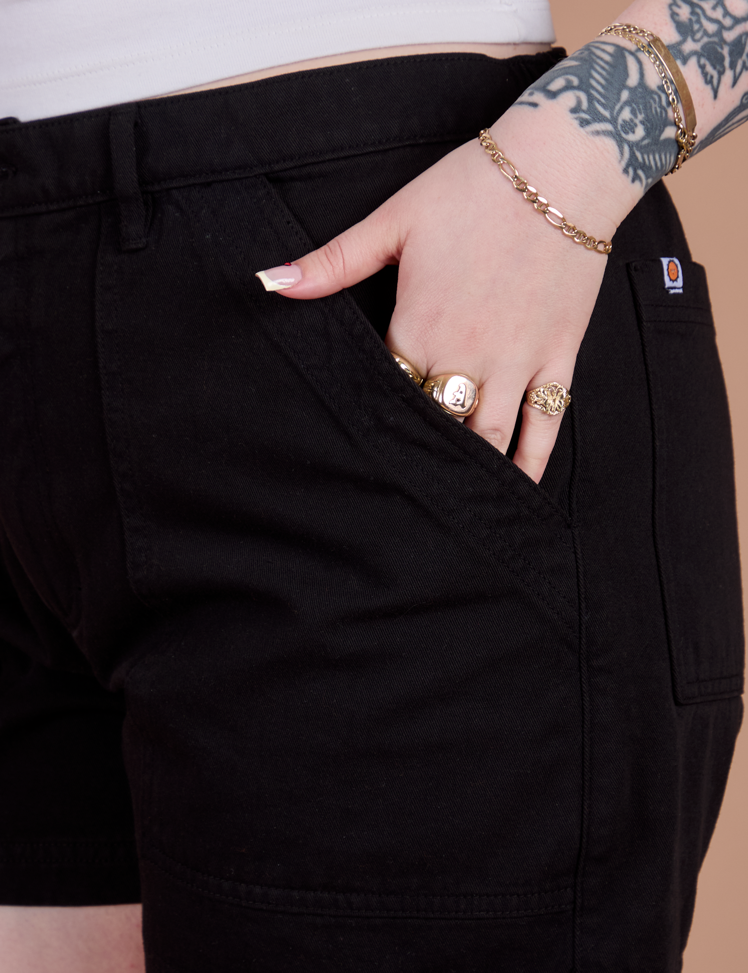 Close up of Sydney's hand in the front pocket of Classic Work Shorts in Basic Black