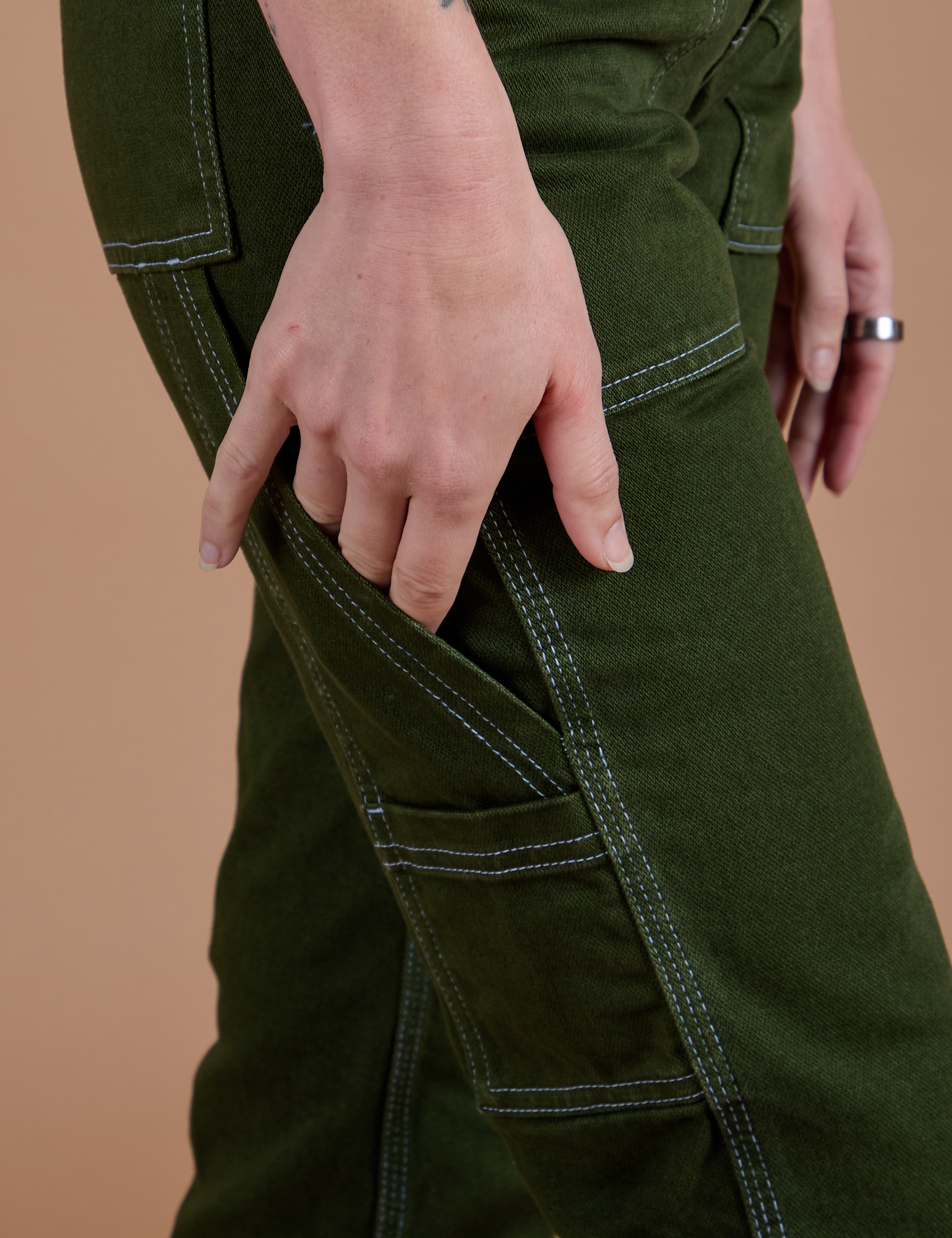 Carpenter Jeans in Evergreen pant leg side view close up on Alex