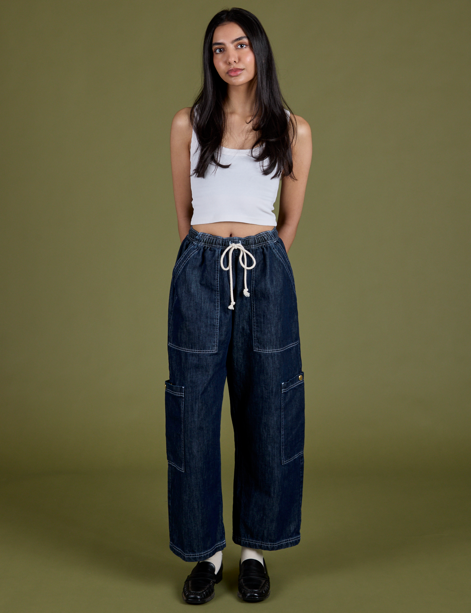 Anjaline 5'7" is and wearing XXS Denim Drop Pocket Pants in Dark Wash paired with vintage tee white Cropped Tank