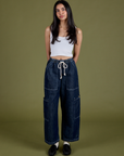 Anjaline 5'7" is and wearing XXS Denim Drop Pocket Pants in Dark Wash paired with vintage tee white Cropped Tank
