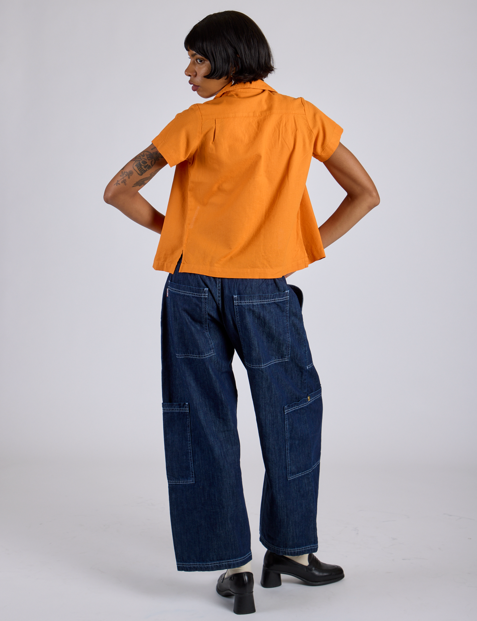 Back view of Pantry Button-Up in Creamsicle Orange and dark wash Denim Drop Pocket Pants