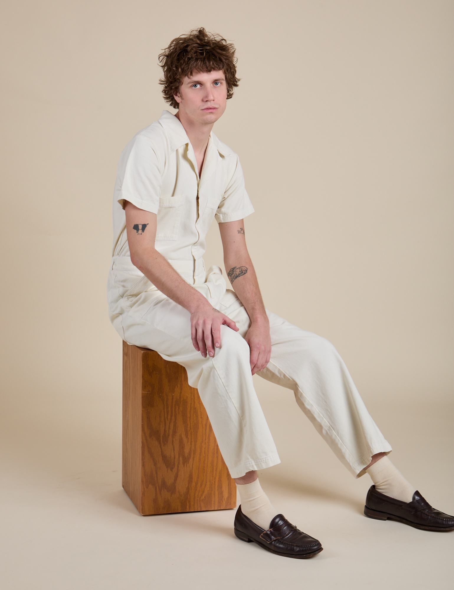 Quinn is wearing Short Sleeve Jumpsuit in Vintage Tee White