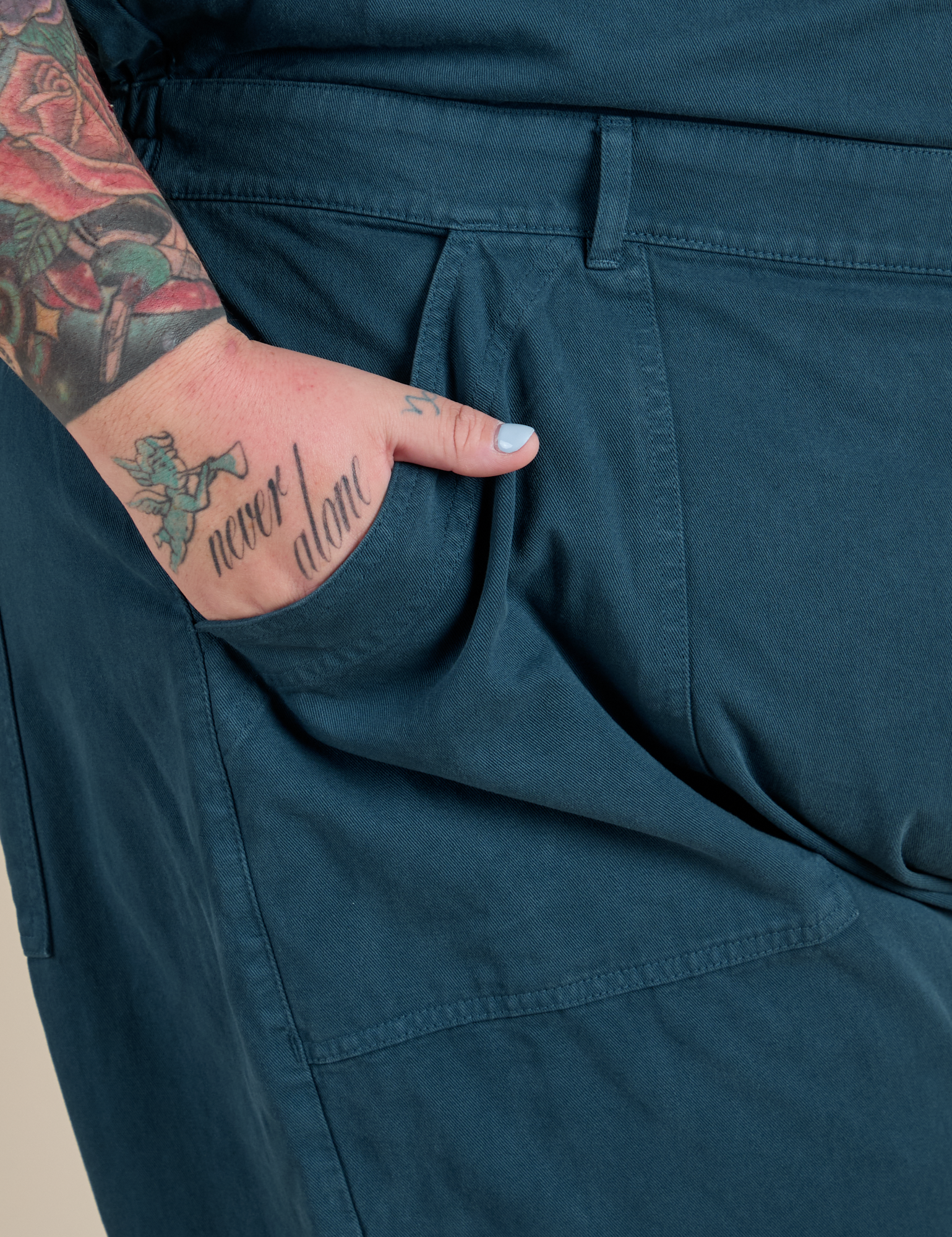 Close up of Sam's hand in the front pocket of Short Sleeve Jumpsuit in Lagoon