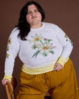 Sam is wearing Floral Long Sleeve Baby Tee in Yellow 