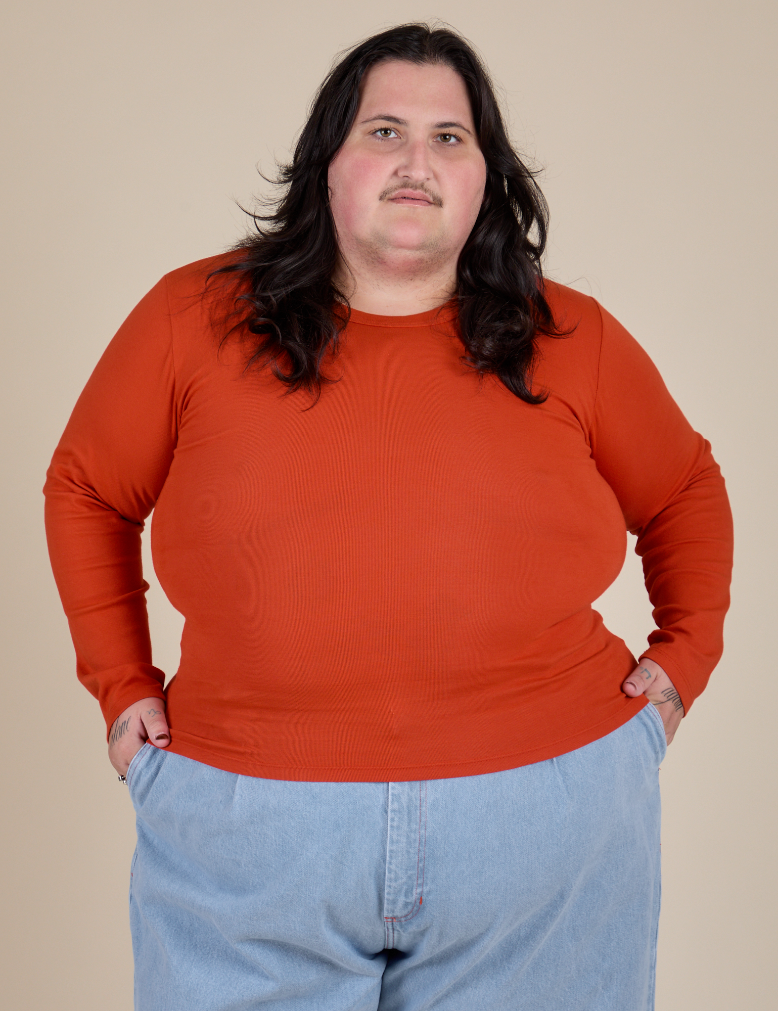 Sam is 5’10” and wearing XL Long Sleeve Baby Tee in Chili Red 
