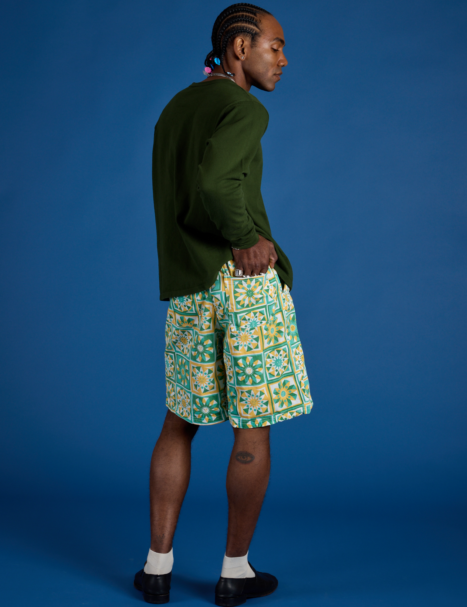 Angled back view of Longline Work Shorts in Spring Quilt Print and evergreen Long Sleeve Burly Tee