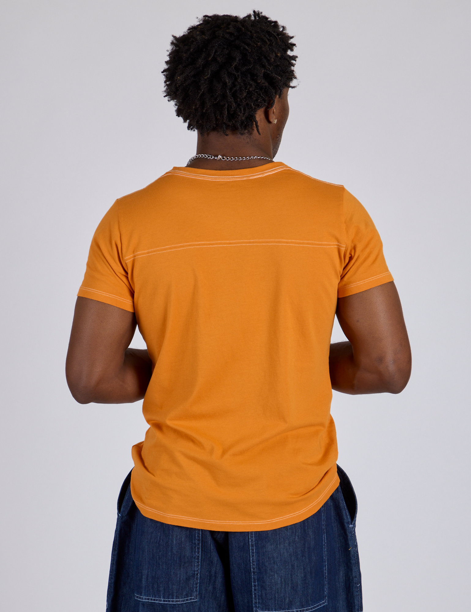Jr. Varsity Tee in Creamsicle Orange back view on Isaac