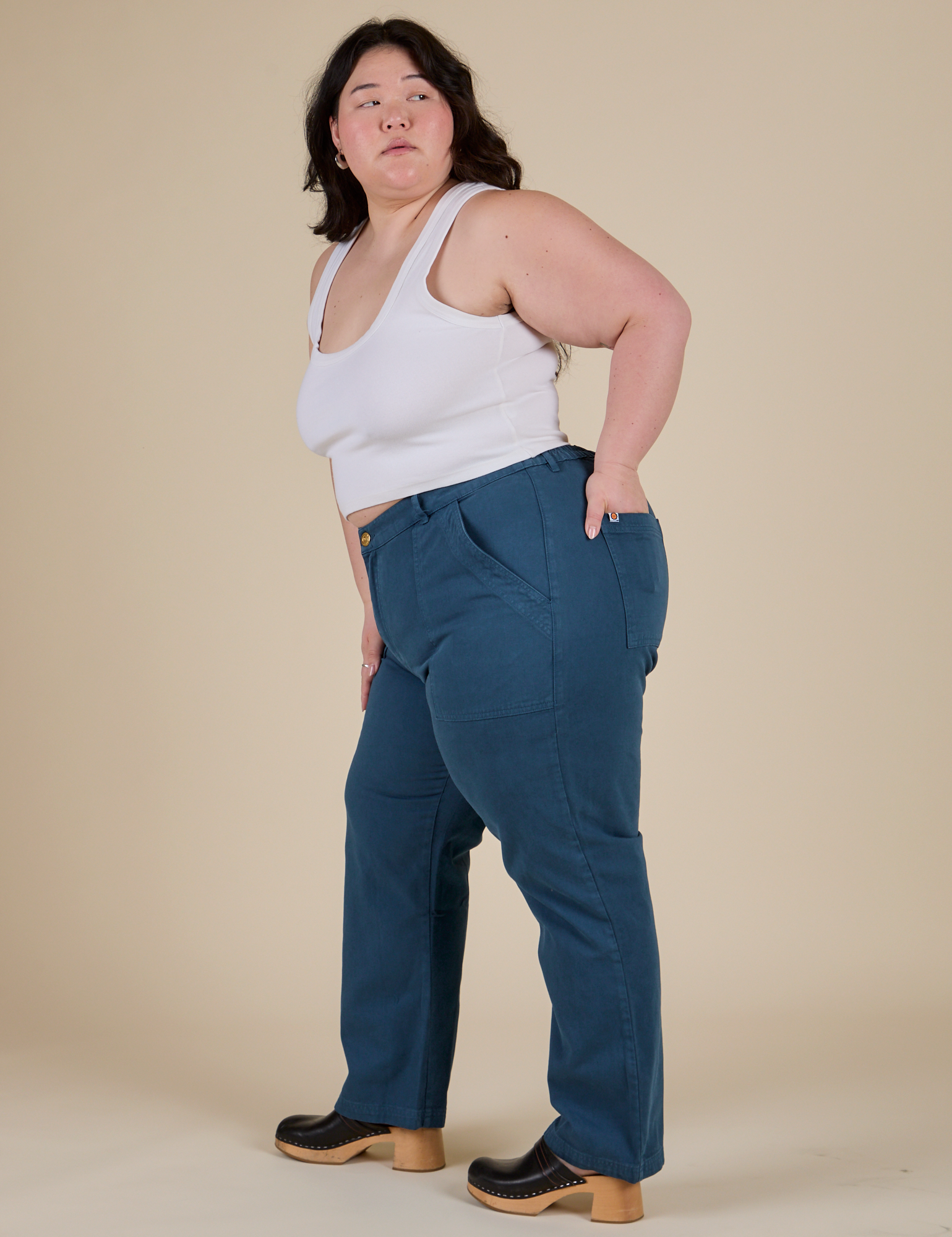 Side view of Work Pants in Lagoon and vintage tee white Cropped Tank on Ashley