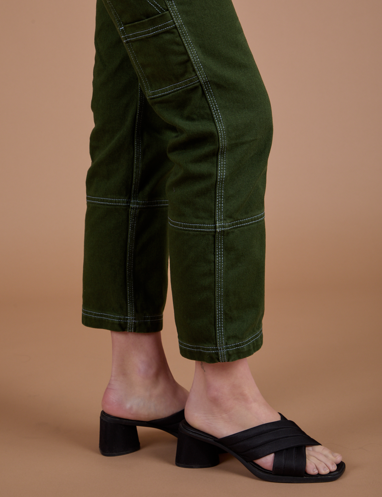 Carpenter Jeans in Evergreen pant leg side view on Alex