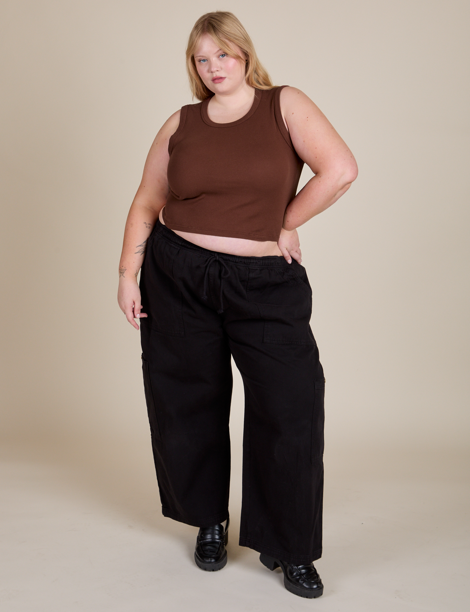 Juliet is wearing Muscle Tee in Fudgesicle Brown paired with black Drop Pocket Cargo Pants
