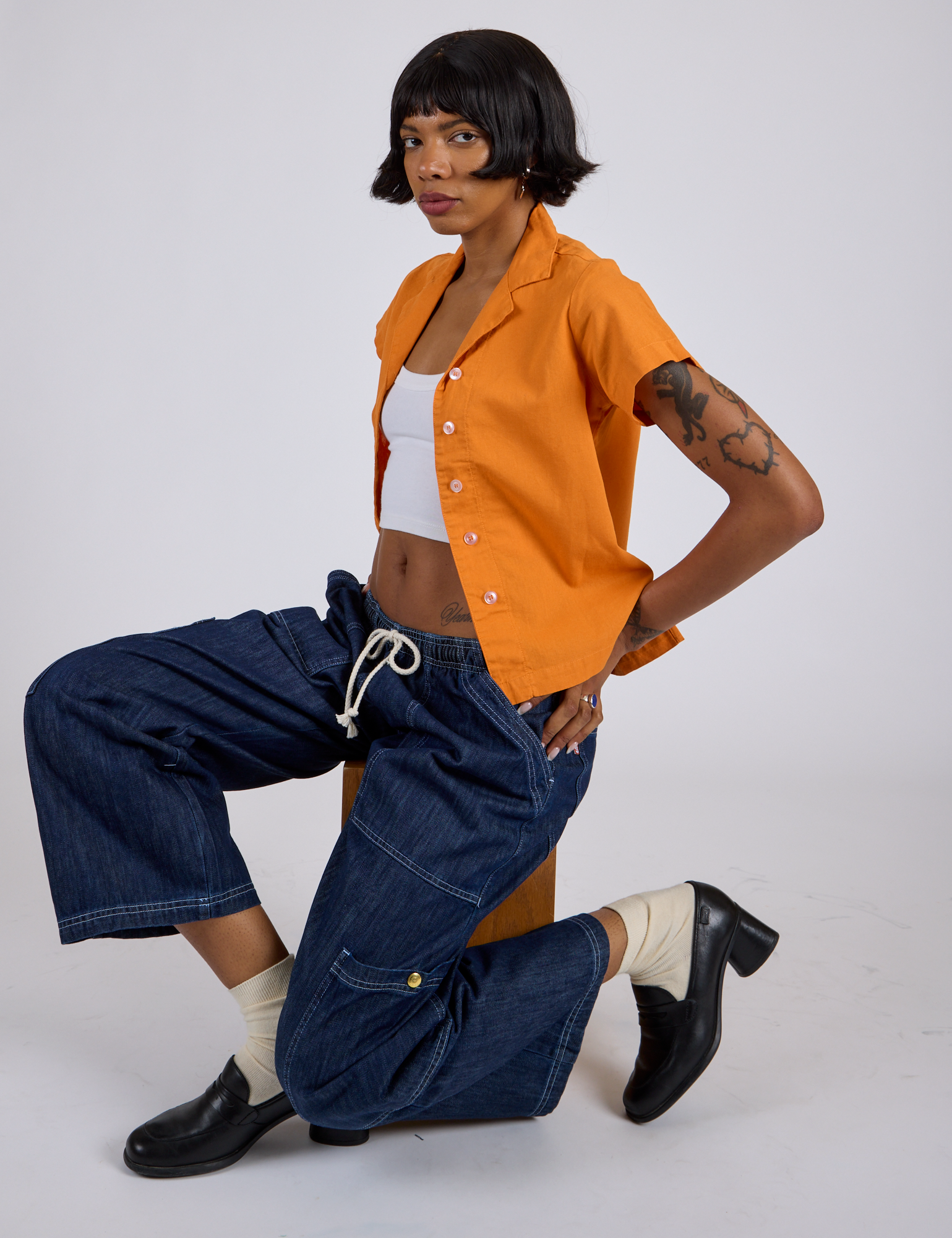 Pantry Button-Up in Creamsicle Orange and dark wash Denim Drop Pocket Pants worn by Kira