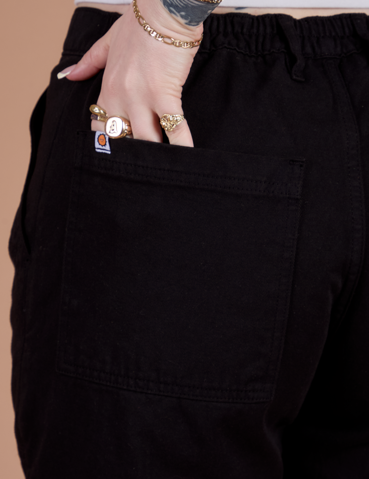 Close up of Sydney's hand in the back pocket of Classic Work Shorts in Basic Black