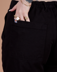 Close up of Sydney's hand in the back pocket of Classic Work Shorts in Basic Black