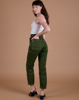 Carpenter Jeans in Evergreen angled back view on Alex