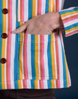 Close up of Alex's hand in the front pocket of Stripe Work Jacket in Rainbow Stripe 