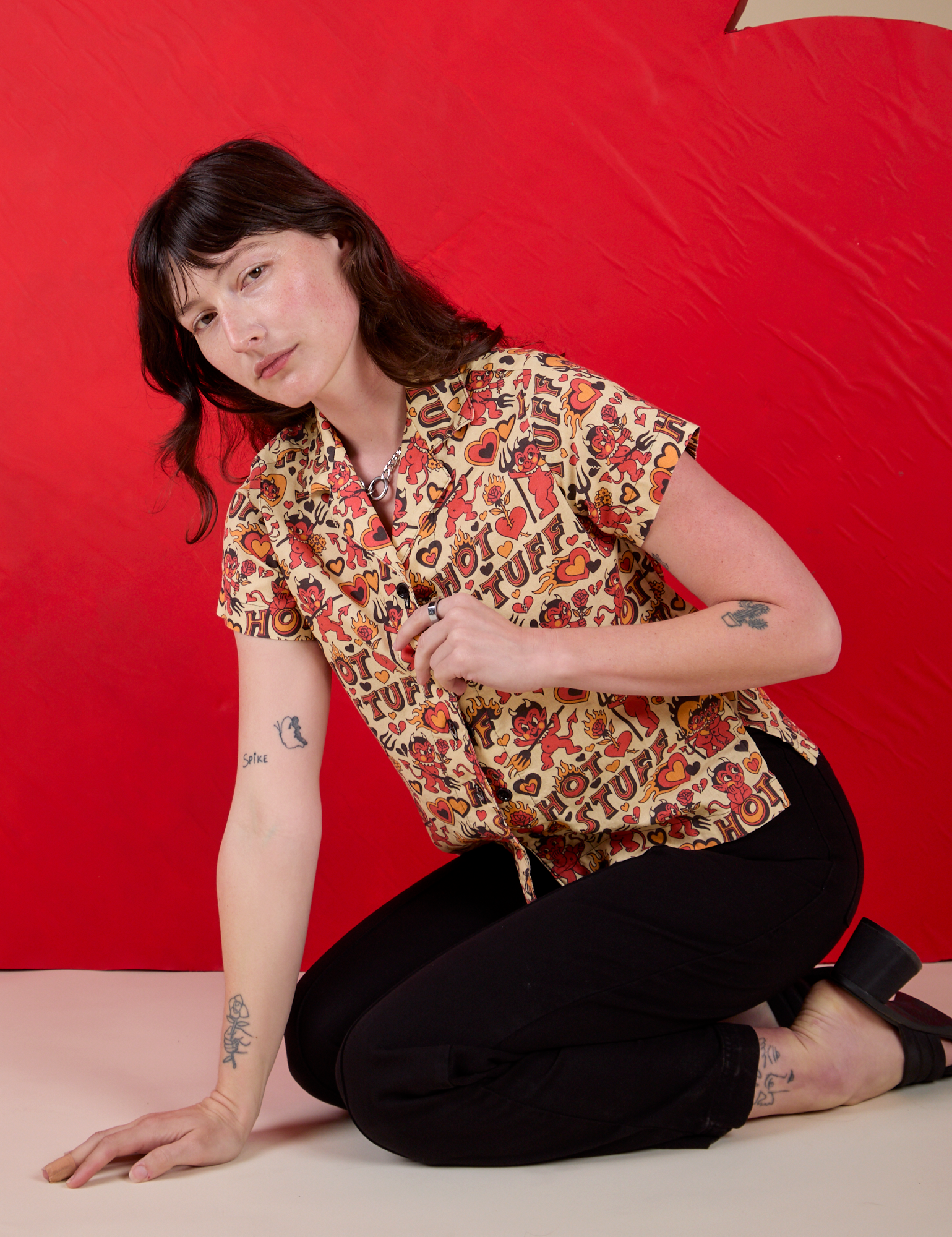 Alex is wearing Hot Stuff Print Pantry Button-Up paired with black Western Pants