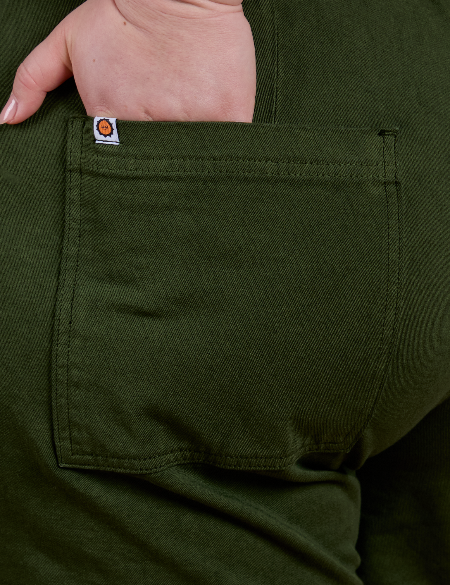 Close up of Ashley's hand in the back pocket of Classic Work Shorts in Evergreen