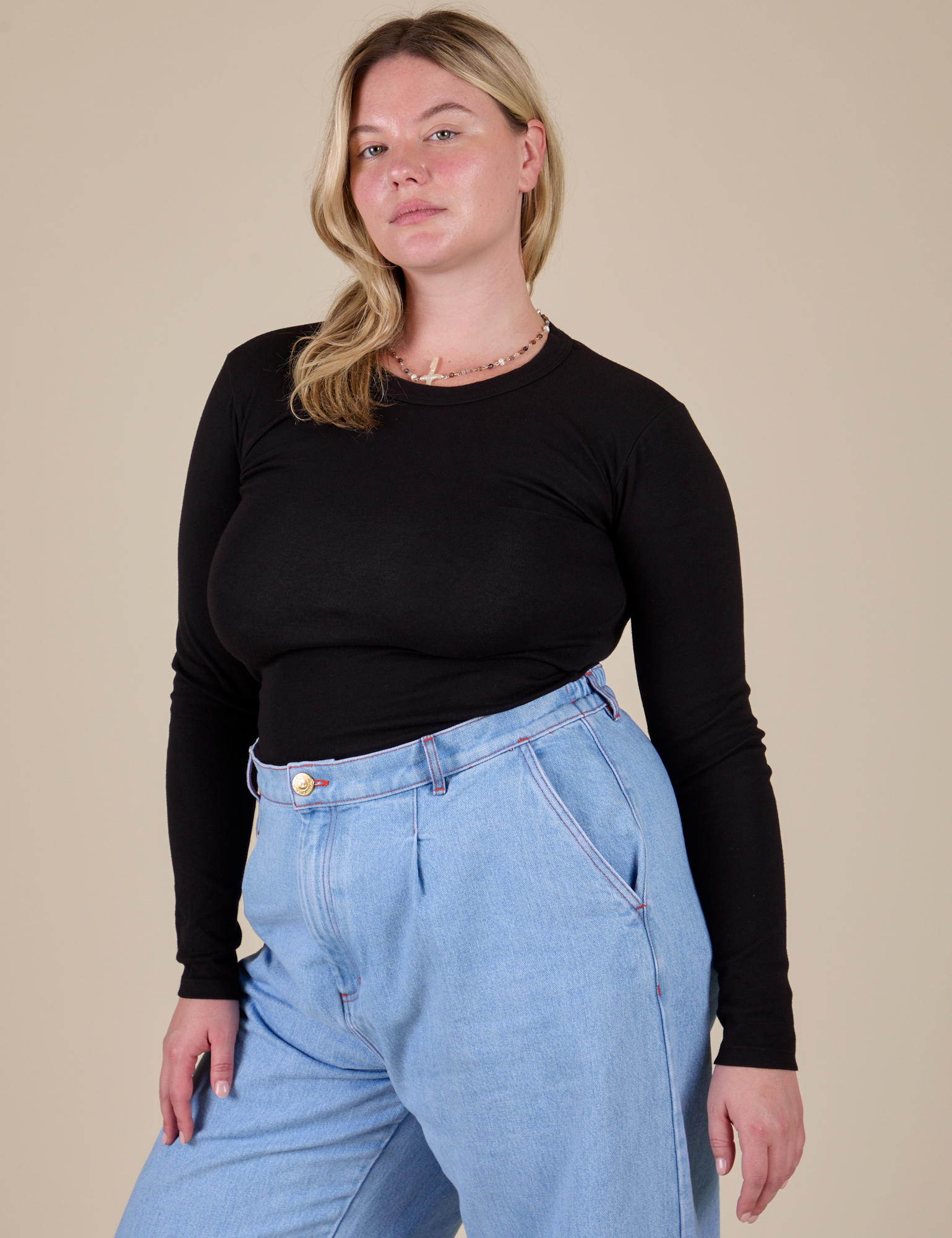 Lish is wearing Long Sleeve Baby Tee in Basic Black tucked into light wash Indigo Wide Leg Trousers