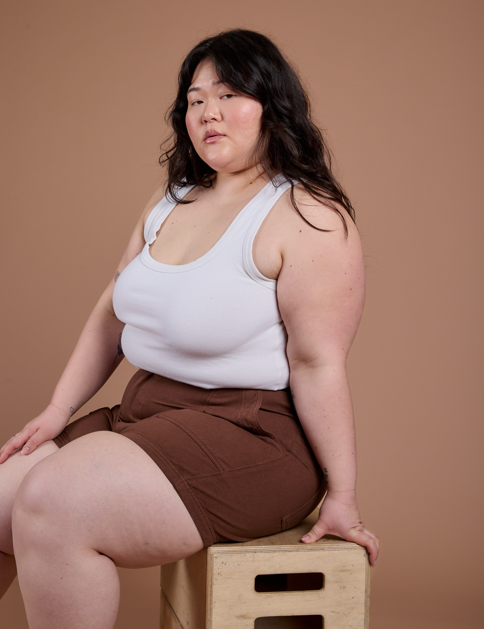 Ashley is wearing Classic Work Shorts in Fudgesicle Brown and Cropped Tank in Vintage Tee White