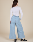 Back view of Long Sleeve Baby Tee in Vintage Tee Off-White and light wash Indigo Wide Leg Trousers