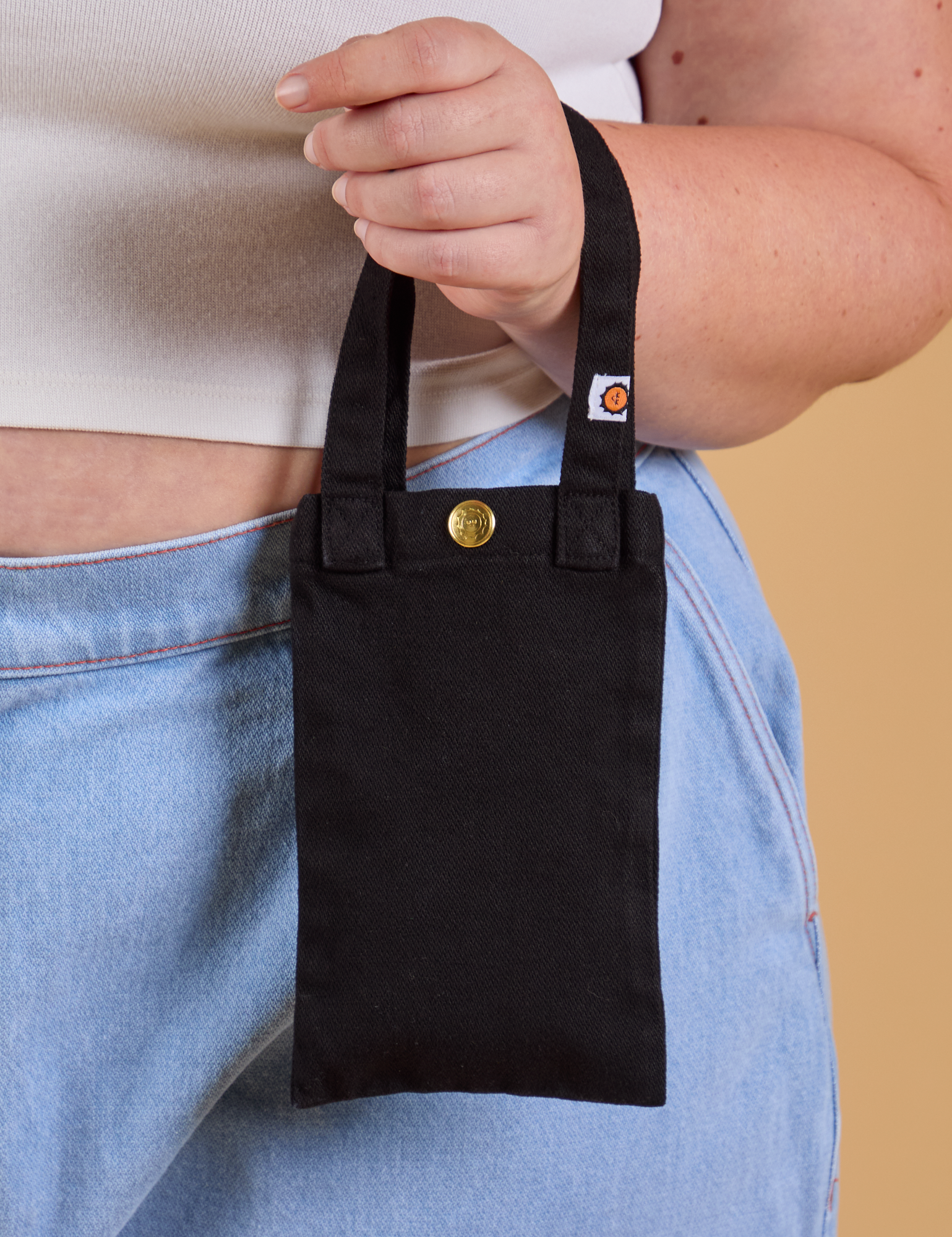 Cell Phone Tote in black held by model