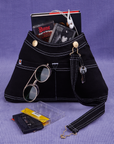 Overall Handbag in Black with book and two cassette tapes in main compartment.